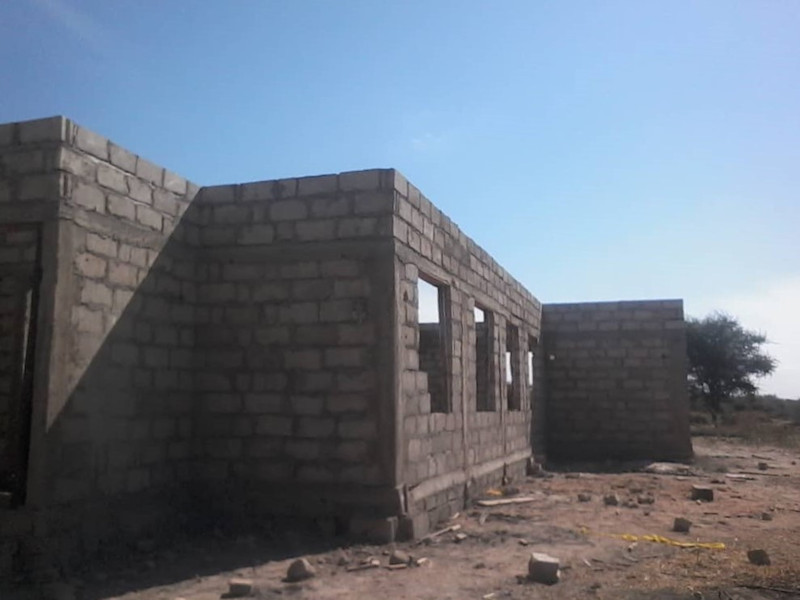 Kirkon rakennustyömaalta Tansaniasta. Tiilistä tehdyssä seinässä ikkuna-aukot. Kattoa ei ole vielä tehty.