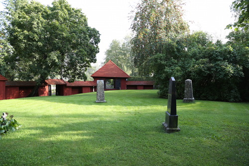 Vanhan hautausmaan hautamuistomerkkejä, taustalla hautausmaata kiertävä aita ja porttihuone.